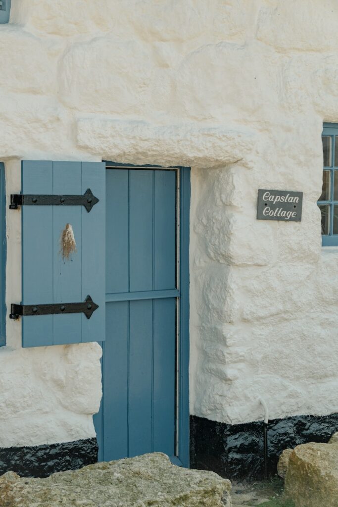 a white building with a blue door and window